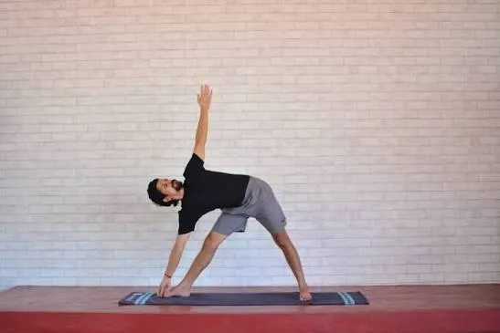 योग का बायोमैकेनिक्स: त्रिकोणासन (Triangle Pose) हैमस्ट्रिंग पर कैसे काम करता है?